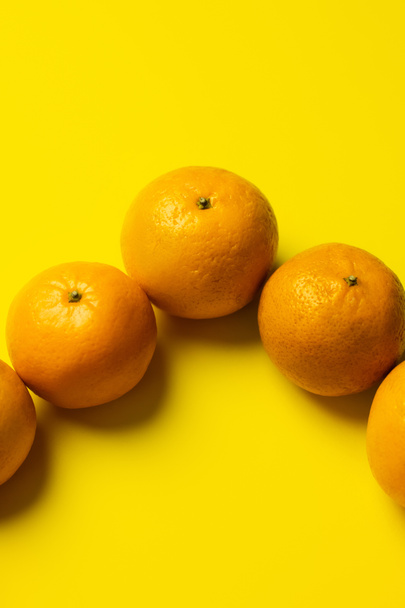 High angle view of tangerines in peel on yellow background - Photo, Image