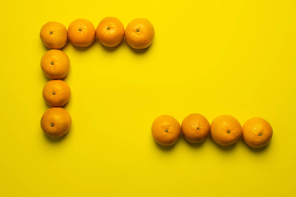 Επίπεδη ωοτοκία με νόστιμα μανταρίνια σε κίτρινη επιφάνεια - Φωτογραφία, εικόνα