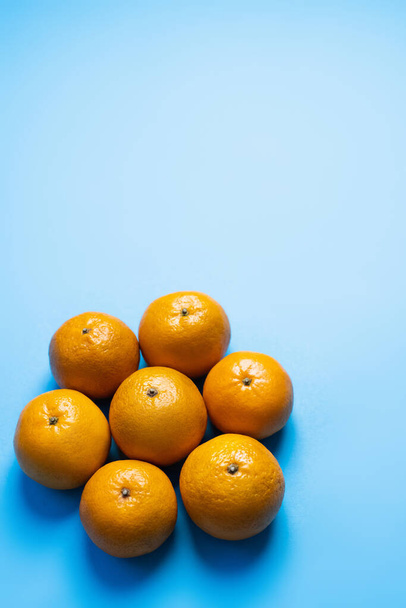 Flat lay with ripe tangerines with shadow on blue background - Photo, Image
