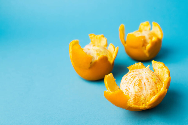Close up view of fresh mandarins in peel on blue background with copy space - Foto, Imagen