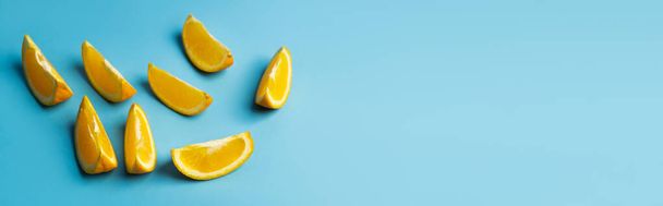 High angle view of cut oranges on blue background, banner  - Photo, image
