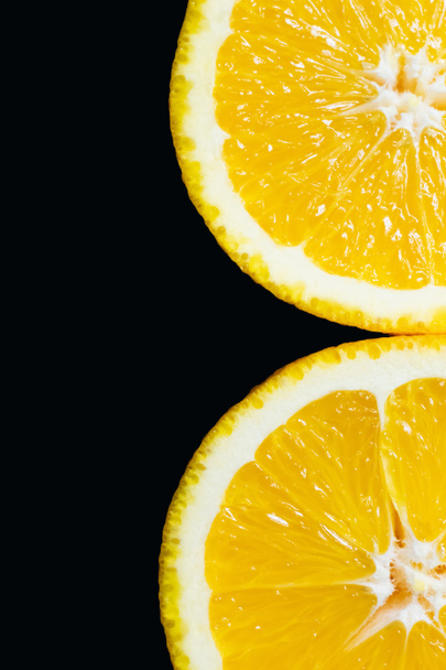 Close up view of slices of tasty orange isolated on black  - Foto, afbeelding
