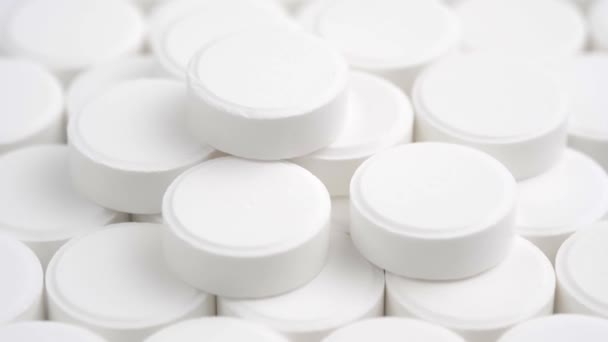 Mnoho bílých medicínských pilulek se otáčí zblízka. Koncept farmaceutického průmyslu a medicíny.  - Záběry, video