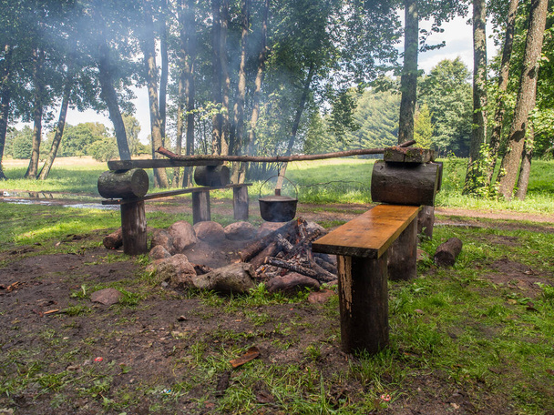 Cuisiner un repas sur un feu de camp dans des récipients métalliques lors d'une excursion en canoë sur la rivière Wieprza - Photo, image