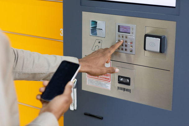 Клиент, использующий автоматизированный терминал самообслуживания или шкафчик. Концепция доставки почты. Высокое качество фото - Фото, изображение