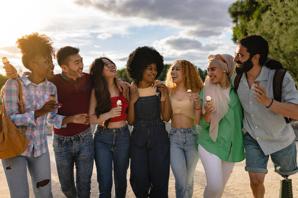 multiracial friends in the park in the summer eat ice cream and have fun - Fotoğraf, Görsel