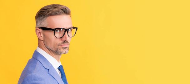 Man face portrait, banner with copy space. mature businessman in elegant jacket and eyeglasses on yellow background, copy space, manager - Photo, image
