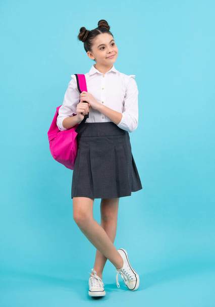 Schoolgirl in school uniform with school bag. Schoolchild, teen student on blue isolated background. Happy teenager, positive and smiling emotions of teen girl - Fotografie, Obrázek