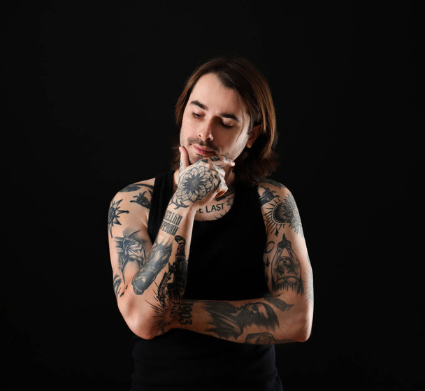 Young man with tattoos on body against black background - Zdjęcie, obraz