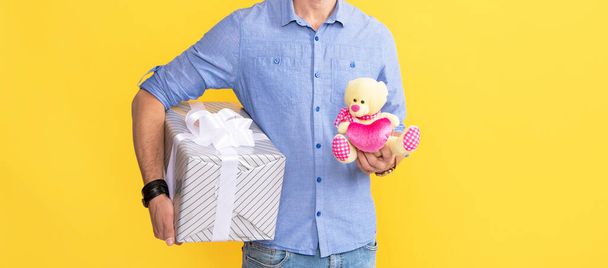 present for womens or mens day. man holding giftbox and toy. cropped man prepare for romance date. guy with occasion greeting. male showing gift box. corporate present. valentines day. - Foto, Imagen