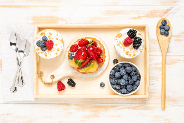 Sweet desserts with fresh berries on wooden background. - Foto, Imagem