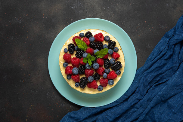 Homemade cake with fresh berries on dark background. - Photo, image