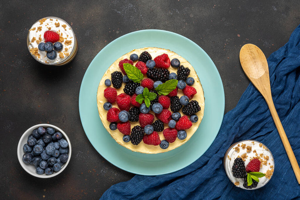Homemade cake with fresh berries and sweet desserts on dark background.  - Foto, Bild