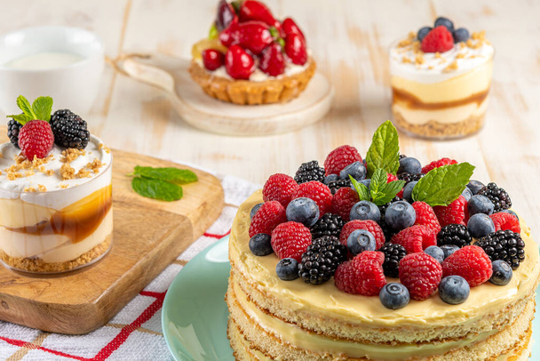 Homemade cake with fresh berries on wooden background.  - 写真・画像