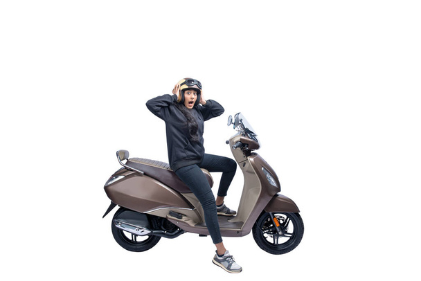 Asian woman with a helmet and jacket sitting on a scooter with a shocked expression isolated over white background - Φωτογραφία, εικόνα