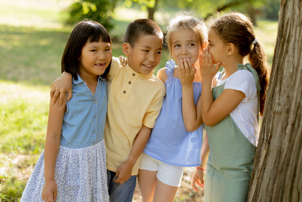 Group of cute asian and caucasian kids having fun in the park - Photo, image