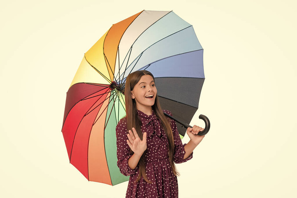 изумленный ребенок держать разноцветный зонтик защиты от дождя изолированы на белом фоне wavig Привет, падение. - Фото, изображение