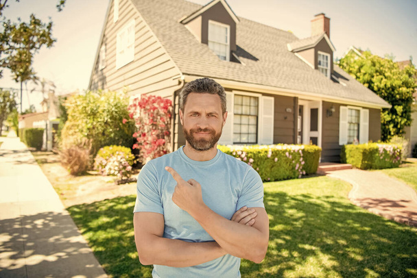 boldog szakállas férfi ujjal mutogat az új ház, ingatlanügynök. - Fotó, kép