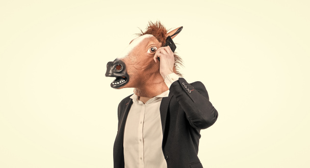 Працьовитий чоловік у конячій голові говорить на мобільному телефоні ізольовано на білому, ділове спілкування
. - Фото, зображення