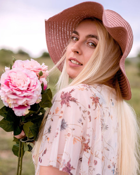 piękna młoda kobieta z bukietem kwiatów w parku - Zdjęcie, obraz