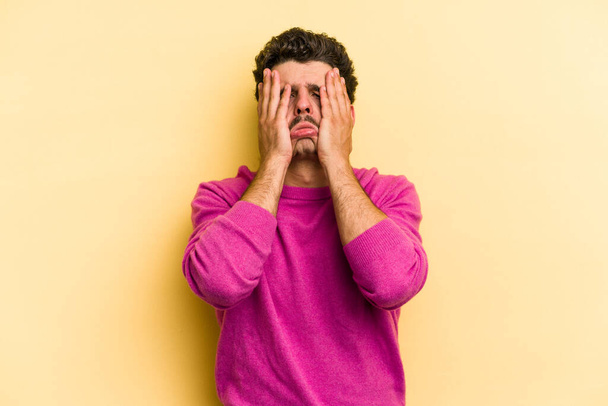 Young caucasian man isolated on yellow background whining and crying disconsolately. - Foto, Imagen