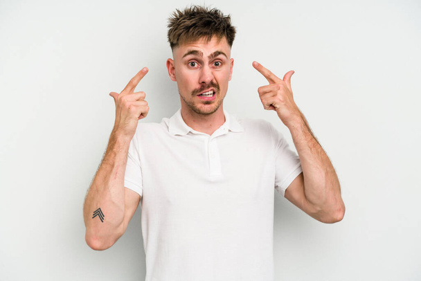 Young caucasian man isolated on white background showing a disappointment gesture with forefinger. - 写真・画像