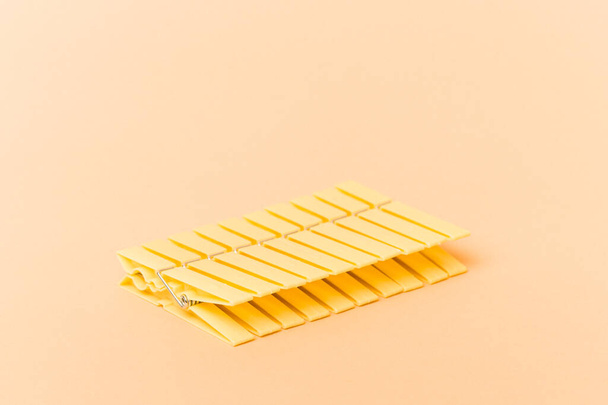Clothes pin row isolated on beige background - Foto, afbeelding