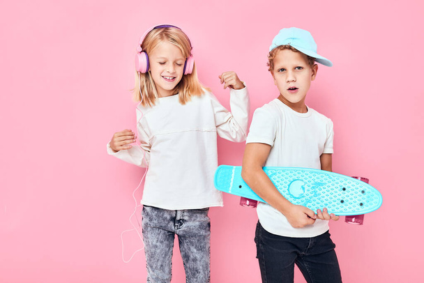 Un par de adorables niños elegantes sonriendo y escuchando música en los auriculares estilo de vida de la infancia. Foto de alta calidad - Foto, imagen