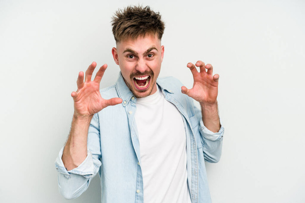 Young caucasian man isolated on white background upset screaming with tense hands. - Photo, Image