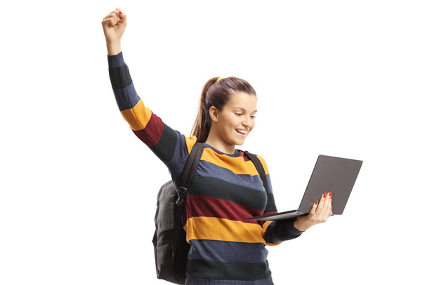 Excited female student holding a laptop and gesturing happiness with raised arms isolated on white backgroun - Fotografie, Obrázek