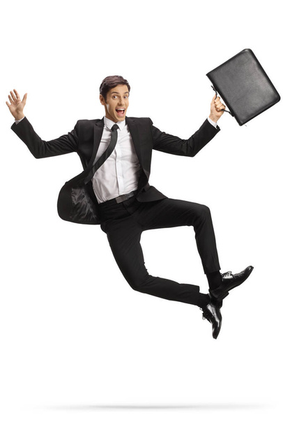 Successfull young businessman with a briefcase jumping isolated on white background - Foto, Imagem