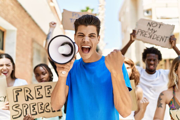 Grupo de jóvenes activistas que protestan con pancartas y usan megáfono en la ciudad. - Foto, imagen