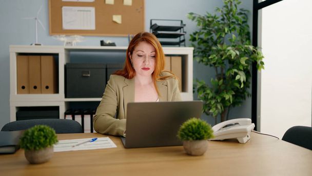 Jovem ruiva mulher trabalhador de negócios usando laptop trabalhando no escritório - Foto, Imagem