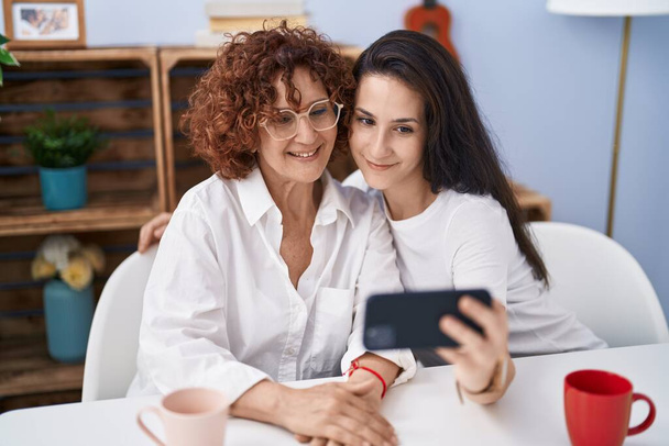 Dos mujeres madre e hija hacen selfie por teléfono inteligente en casa - Foto, Imagen