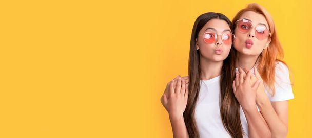 Mother and daughter child banner, copy space, isolated background. blow kiss. mother and daughter in sunglasses. beauty and fashion. female fashion model - Foto, imagen