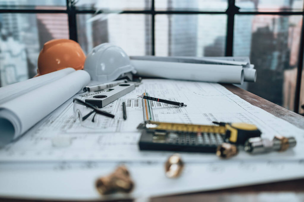 Engineering working with drawings inspection on the office desk and Calculator, triangle ruler, safety glasses, compass, vernier caliper on Blueprint. Engineer, Architect, Industry and factory concept. - Φωτογραφία, εικόνα