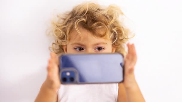 Ένα μικρό κορίτσι που χρησιμοποιεί ένα κινητό τηλέφωνο για να τραβήξει φωτογραφία - Πλάνα, βίντεο