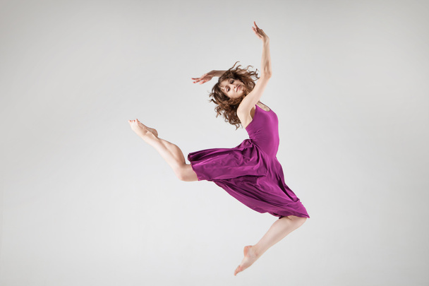 Young ballet dancer wearing purple dress over grey - Fotografie, Obrázek