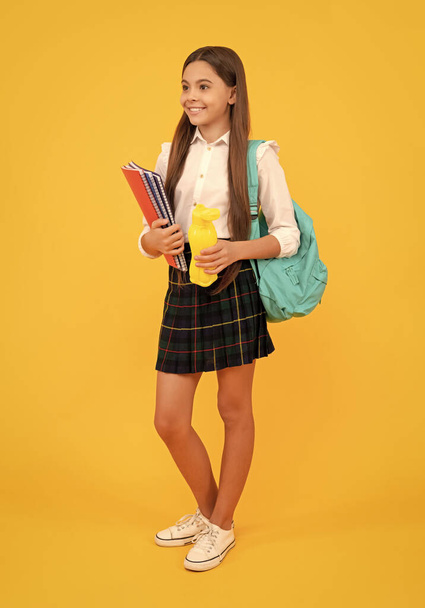 cheerful kid going on lunch. teenager student hold planner notebook. education in high school. schoolgirl with apple and water bottle. back to school. teen girl ready to study. happy childhood. - Foto, Imagem