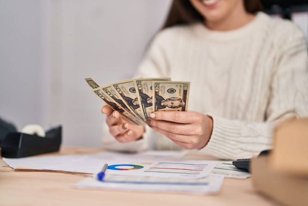 Jeune femme e-commerce ouvrier d'affaires comptant les dollars au bureau - Photo, image