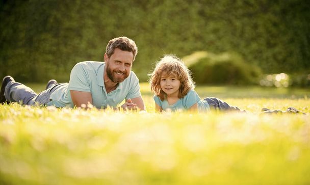 ευτυχισμένη οικογένεια του πατέρα και του γιου αγόρι χαλαρώστε στο πάρκο καλοκαίρι πράσινο γρασίδι, παιδική ηλικία. - Φωτογραφία, εικόνα