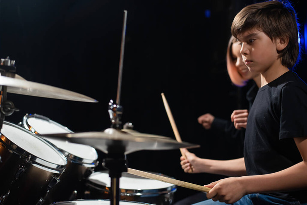 Young woman teaching boy to play drums - Fotografie, Obrázek