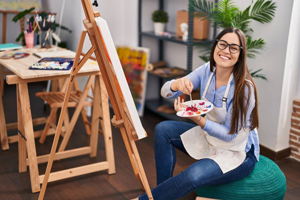 Young woman artist smiling confident drawing at art studio - Фото, изображение