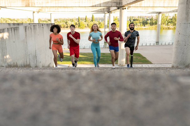Early morning training. Happy multiracial people running up the stairs bridge. Live a healthy lifestyle. - Fotoğraf, Görsel