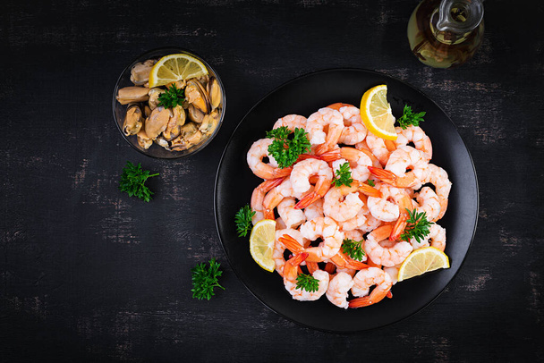 Shrimps, prawns on black plate. Boiled shrimps, prawns. Seafood. Top view, overhead - Zdjęcie, obraz
