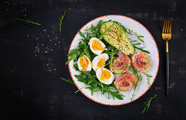 Σάντουιτς με σολομό και βραστά αυγά και αβοκάντο. Keto, κετογενής πρωινό δίαιτα ή μεσημεριανό γεύμα. Κάτοψη, γενικά - Φωτογραφία, εικόνα
