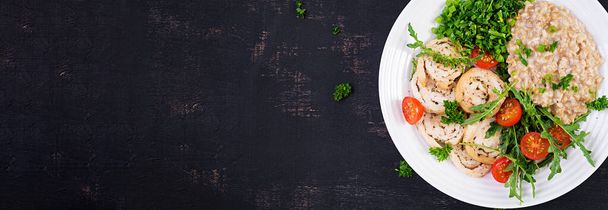 Обед или обед. Тарелка с овсянкой, куриным филе, помидорами и зелеными травами. Здоровая еда. Вид сверху, баннер - Фото, изображение