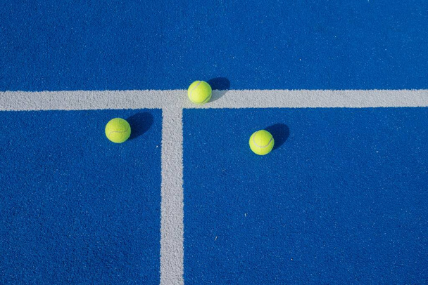 three paddle tennis balls on a blue court, racket sports concept - Foto, imagen