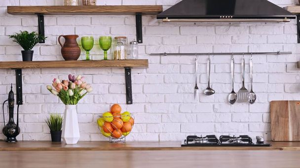 An interior design of cozy kitchen with white brick wall and range hod and fresh fruits - Foto, Bild
