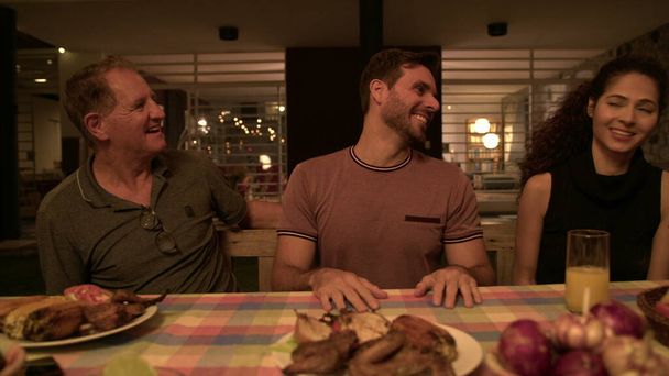 Чоловік дає позитивні новини сім'ї під час вечері на подвір'ї. Група людей, що святкують оголошення GREAT
 - Фото, зображення